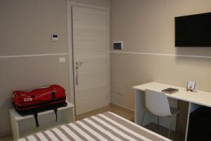 una stanza con una valigia rossa seduta su un tavolo di Lasso B&B a Corigliano Calabro