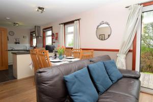 ein Wohnzimmer und eine Küche mit einem Sofa und einem Tisch in der Unterkunft Rowan Cottage in Blairmore