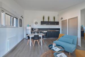 sala de estar con sofá azul y mesa en La Petite Maison Cocooning - De plain pied, en Mésanger