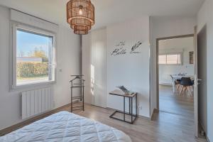 1 dormitorio con cama, mesa y ventana en La Petite Maison Cocooning - De plain pied, en Mésanger