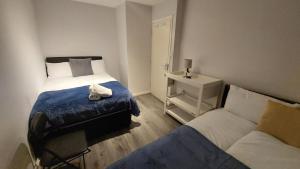 a small bedroom with two beds and a couch at 2-Bed Apartment in King's Cross Central London in London