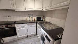 a small kitchen with a sink and a microwave at 2-Bed Apartment in King's Cross Central London in London