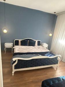 a bedroom with a bed with a blue wall at Visage appointment in Strumica