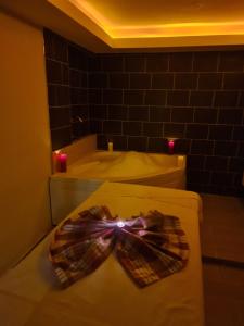 uma gravata borboleta sentada numa cama na casa de banho em Olivia Palm Hotel em Cirénia