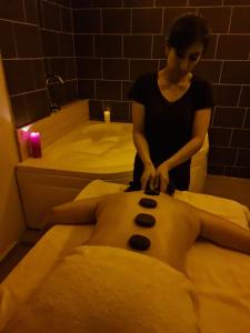 Womanolithing a mans back in a bath w obiekcie Olivia Palm Hotel w mieście Kirenia