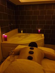 a man laying in a bath tub in a bathroom at Olivia Palm Hotel in Kyrenia