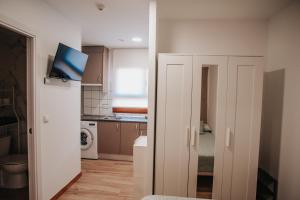 a room with a kitchen with a tv on a wall at Poloestudios in Zaratán
