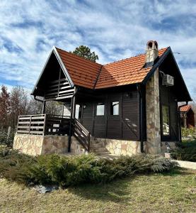 una pequeña casa con techo rojo en un campo en Ozoni & Sauna, en Sopot