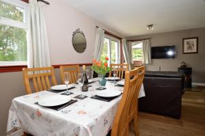 ein Esszimmer mit einem Tisch und einem Sofa in der Unterkunft Rowan Cottage in Blairmore