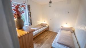 ein kleines Zimmer mit 2 Betten und einem Fenster in der Unterkunft Schillhörn - Urlaub mit Wasserblick in Neuharlingersiel