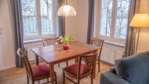 a dining room table with a vase of flowers on it at Schillhörn - Urlaub mit Wasserblick in Neuharlingersiel