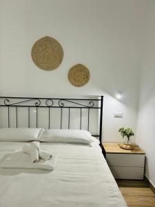 a bedroom with a large white bed and two baskets on the wall at Marina Casa Vacanza in Capoterra +28 photos