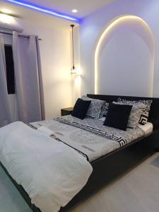 a bedroom with a large bed with an arched headboard at Entré Quartier Jack in Cotonou