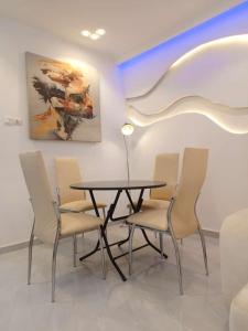 a table and chairs in a room with a painting at Entré Quartier Jack in Cotonou