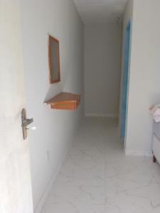 pasillo con suelo de baldosa blanca y estante de madera en Suíte Sunflower 103 en Rio das Ostras