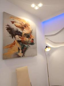 a painting hanging on a wall next to a lamp at Entré Quartier Jack in Cotonou