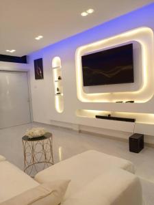 a living room with a large tv on a wall at Entré Quartier Jack in Cotonou