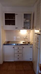 - une cuisine avec des placards blancs et un évier dans l'établissement Apartamentos Sol Isla, à Arenal d'en Castell