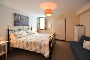 a bedroom with a large bed and a couch at Pottery Cottage, Lochans Lodge in Stranraer