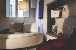 Santa Maria a MonteにあるART SUITE GALLERY - Tuscany - medieval town close to Florence, Pisa, Lucca, Chianti Zone, Versiliaの白いソファと暖炉のあるリビングルーム