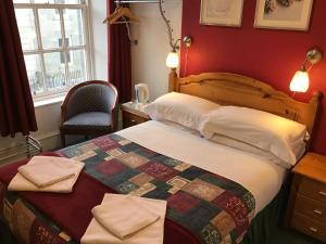 a hotel room with a bed and a chair at The Royal Crown Guest House in Aberdeen