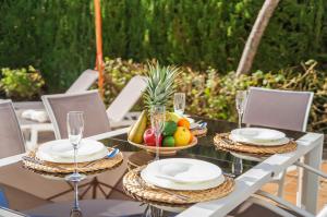 - une table avec un bol de fruits et des verres à vin dans l'établissement Traumhafte Villa Marisol für 8 Gäste am Meer, à Alcúdia
