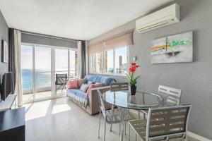 uma sala de estar com uma mesa de vidro e um sofá em Primera línea de playa em Alicante