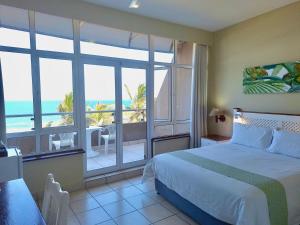 a bedroom with a bed and a view of the ocean at Salt Rock Hotel and Beach Resort in Ballito