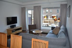 a living room with a blue couch and a television at Funäs Ski Lodge in Funäsdalen