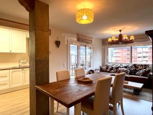 uma cozinha e sala de estar com uma mesa de madeira e cadeiras em Apartament Les Vernedes em Sort