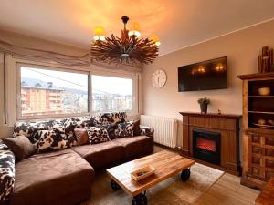 uma sala de estar com um sofá e uma lareira em Apartament Les Vernedes em Sort