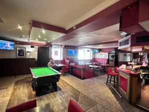 um quarto com uma mesa de bilhar e um bar em Brig Inn Hotel em Aberdeen