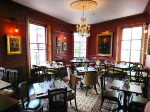 a restaurant with tables and chairs in a room at Elegant Art Deco whole apartment 2mins to Hyde Park, 8mins to Bayswater, Nottinghill, Paddington in London