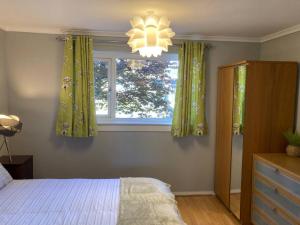 a bedroom with a bed and a window and a chandelier at Comfy 1 bedroom flat with free parking in Glasgow