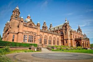 een groot bakstenen gebouw met een binnenplaats ervoor bij Comfy 1 bedroom flat with free parking in Glasgow