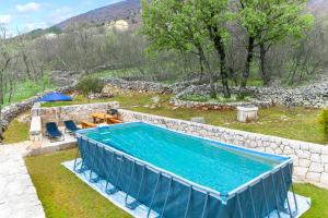 una piscina en un patio junto a una pared de piedra en Villa Čelinka, en Svib