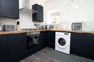 a kitchen with a washing machine and a washer at Norton Views by Afan Valley Escapes in Port Talbot