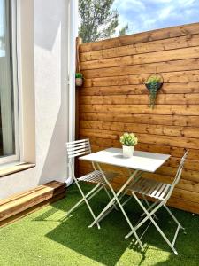 a table and chairs on a patio with a wooden wall at CHAMBRE d'Hôtes avec PISCINE & KITCHENETTE in Saint-Geniès-des-Mourgues