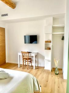 a bedroom with a desk and a tv on a wall at CHAMBRE d'Hôtes avec PISCINE & KITCHENETTE in Saint-Geniès-des-Mourgues