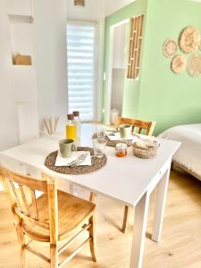 una mesa de comedor blanca con 2 sillas y comida en ella en CHAMBRE d'Hôtes avec PISCINE & KITCHENETTE en Saint-Geniès-des-Mourgues