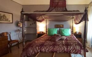 - une chambre avec un lit à baldaquin et des oreillers verts dans l'établissement Rana Cantante, à Mombercelli