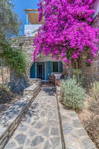 a bougainvillea hanging over a stone walkway at Lefkes Village Living in Lefkes
