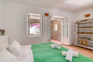 um quarto com uma cama verde e 2 almofadas em Lefkes Village Living em Lefkes