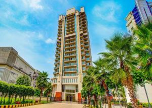 a tall building with palm trees in front of it at Rhythm Gurugram, Hotel & Suites, Sohna Road, Sector 68 in Gurgaon