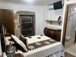 1 dormitorio con 1 cama en una habitación con chimenea en Casa Bralo, en Padrón