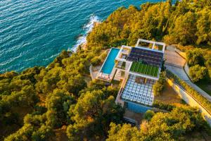 an aerial view of a house with a tennis court at Amberton Green Villas Corfu in Corfu