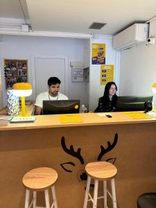 two people sitting at a counter in an office at Onefam Les Corts in Barcelona