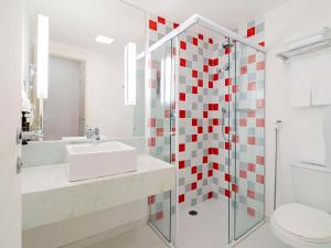 a bathroom with a sink and a shower at Mercure Sao Paulo Moema Times Square in Sao Paulo