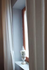 un vase assis sur une étagère à côté d'une fenêtre dans l'établissement Rana Cantante, à Mombercelli