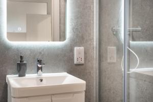 a bathroom with a white sink and a mirror at The Hertfordshire Hideaway in Potters Bar